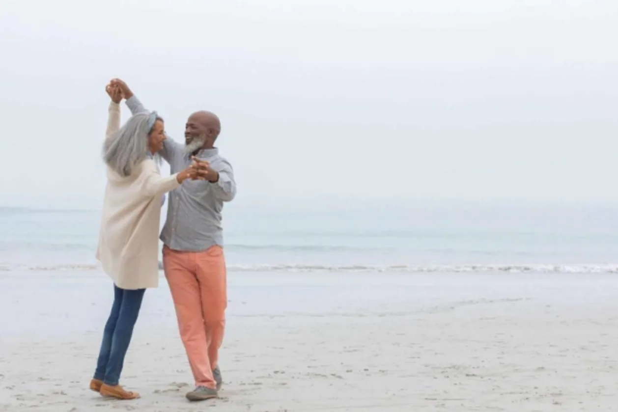 mature couple dancing on beach